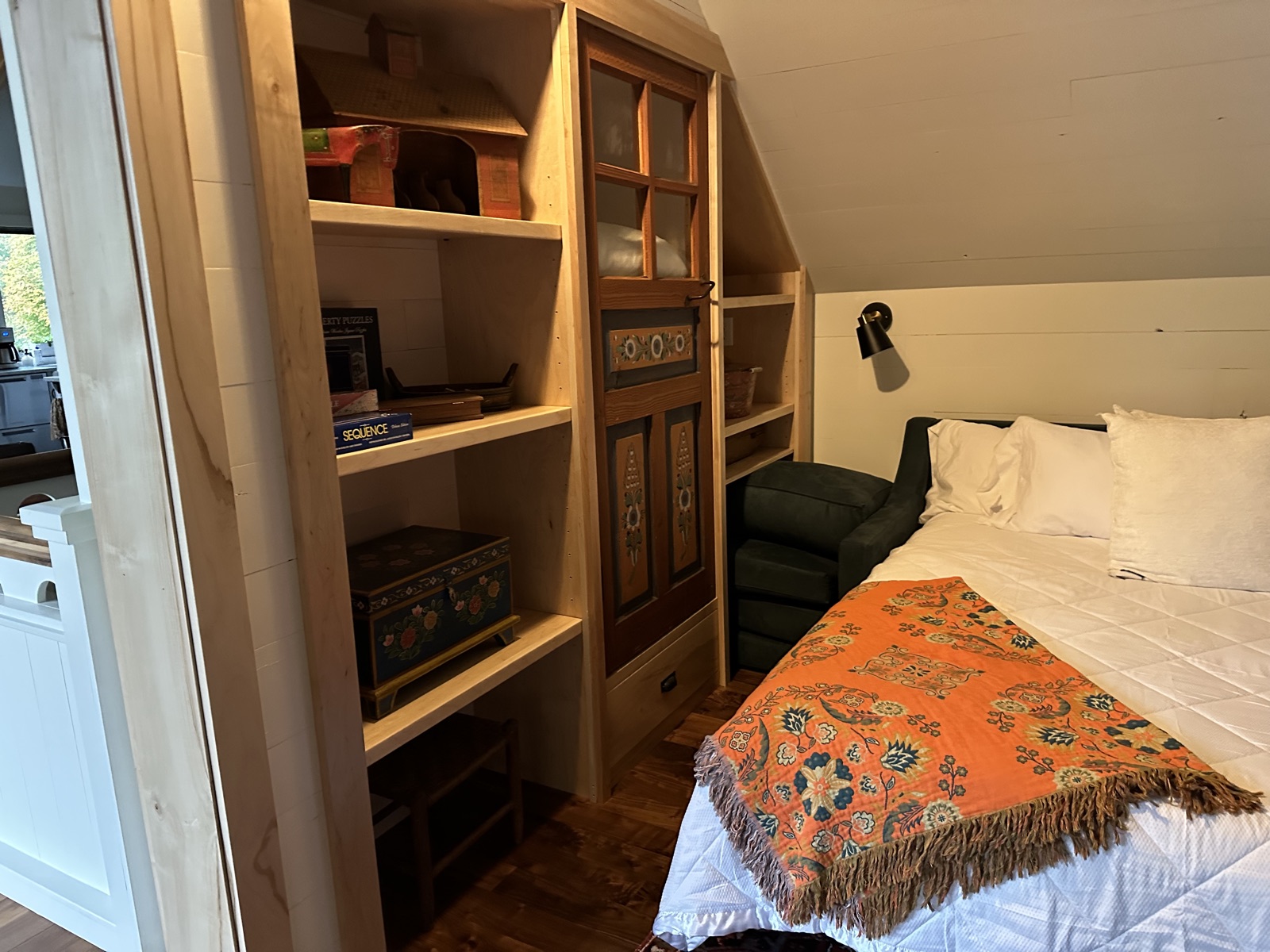 Bed nook with built-in shelves and orange throw