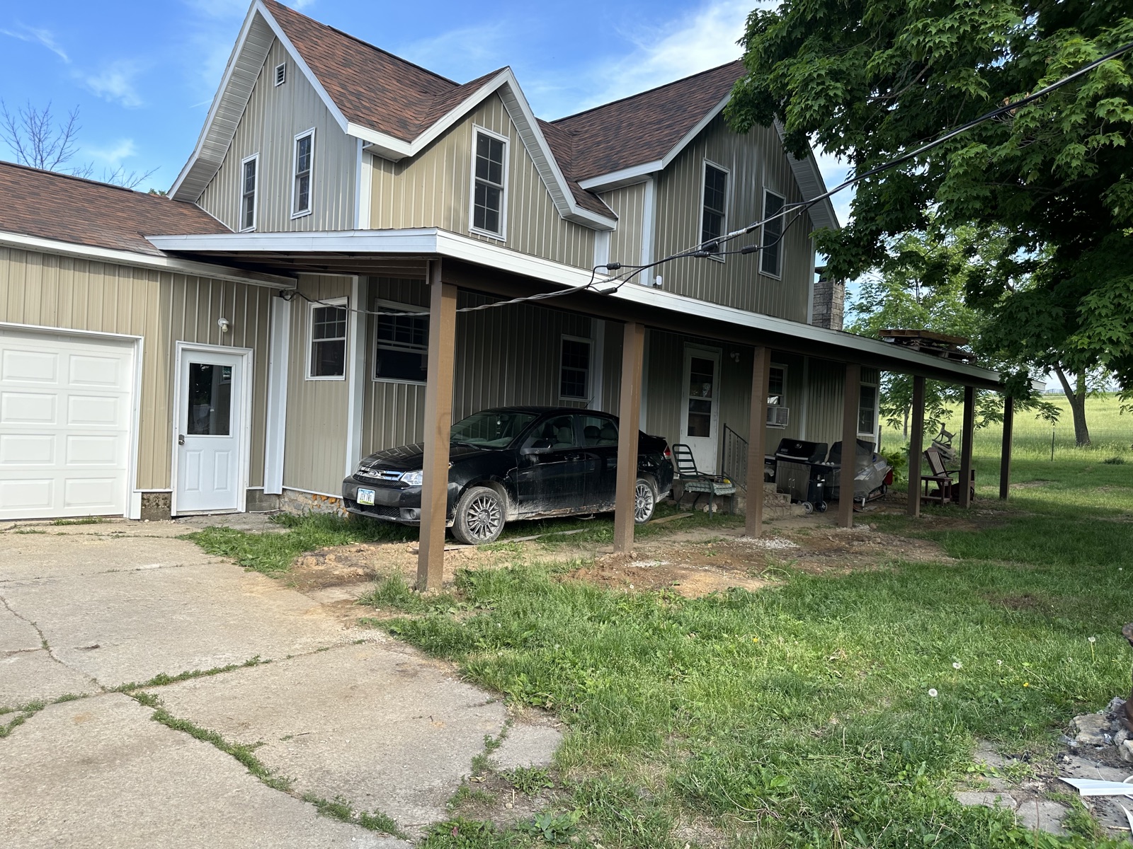 Green farmhouse with front carport