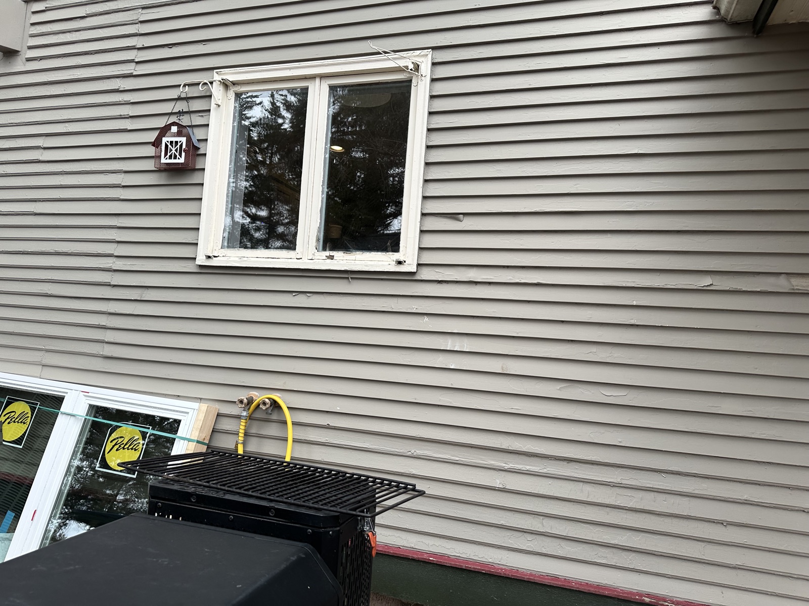 Grey house siding with Pella window and grill